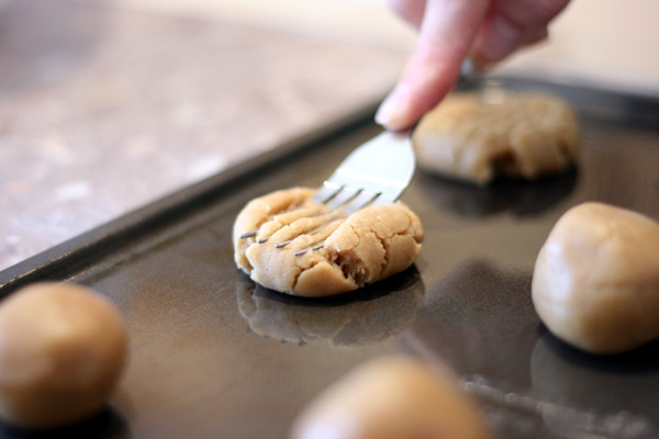 pressing the dough balls with a fork