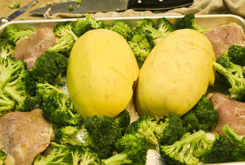spaghetti squash broccoli and chicken on a baking sheet pan