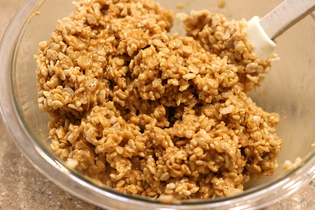 Mixing Rice Krispies together with peanut butter