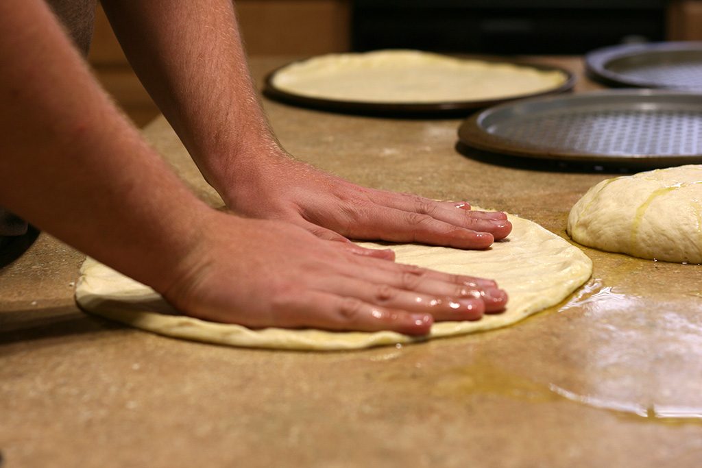 form pizza dough into pizza shape