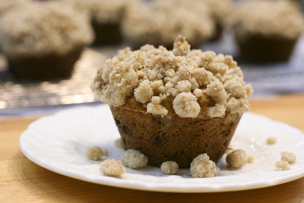 banana muffin with streusel crumb topping on a plate